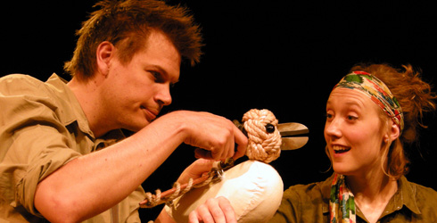 Two actors holding a wooden bird puppet