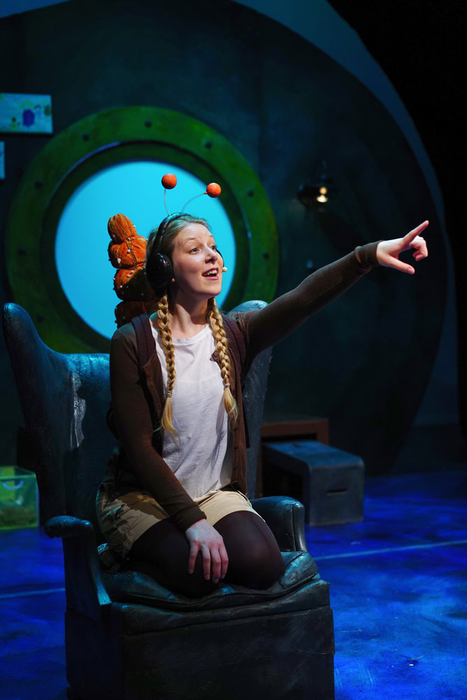 The daughter dressed as a snail pointing into the distance,
