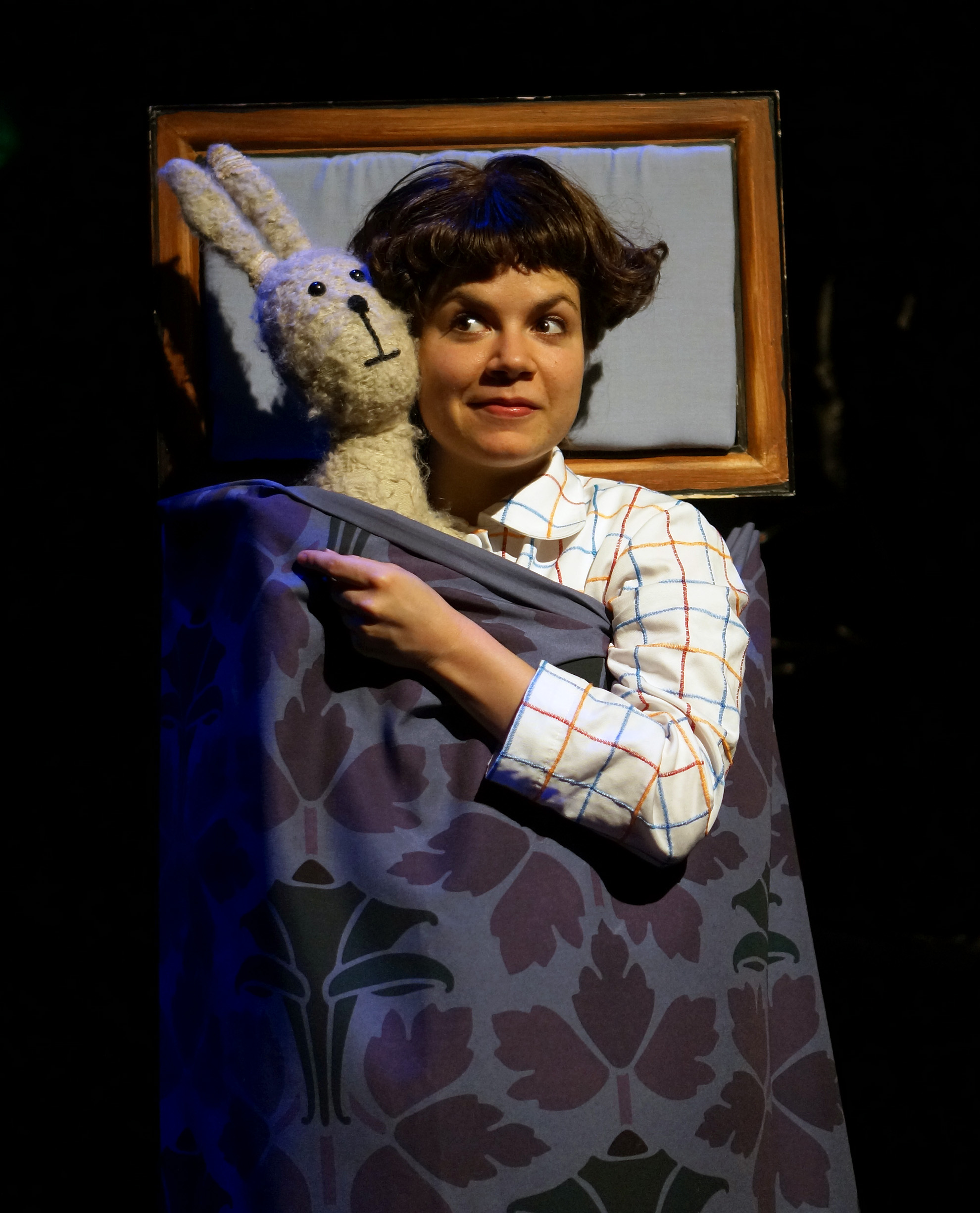 Emily and rabbit lie in bed under the covers