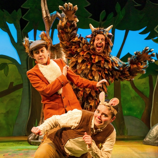 Actors in Mouse, Fox and Gruffalo costume standing behind one another against a wood background.