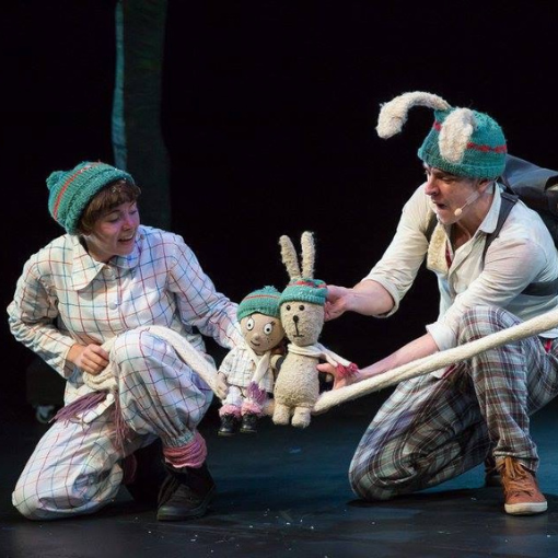 Main and side character with dolls on stage.